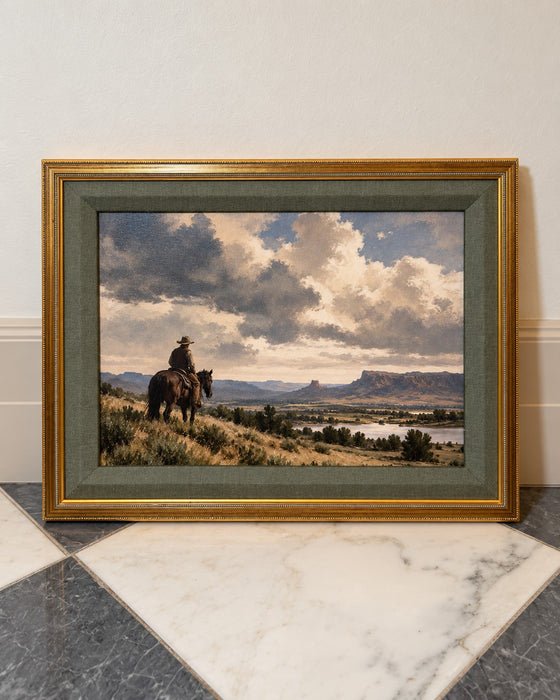 The Long View framed art leaning against a cream wall on a marble floor, showing the antiqued gold frame and wide sage green matting